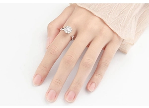Detailed view of silver flower spinner ring with rhinestones worn on a finger
