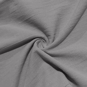 Detailed macro view of dark grey linen fabric texture and natural drape for men's pants