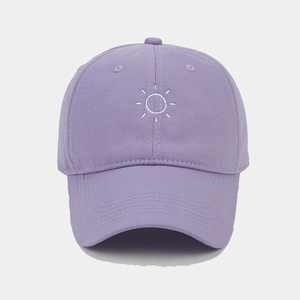 Detailed close-up of purple cotton baseball cap with white sun embroidery and curved brim