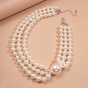Elegant triple-strand faux pearl necklace with a large accent pearl and silver clasp