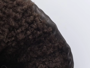 Detail of lychee textured leather jacket with thick warm brown faux shearling lining