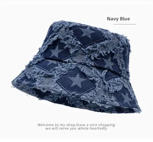 Close-up of frayed star design on navy blue denim bucket hat showing fabric texture
