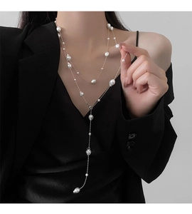 Detailed view of layered baroque pearl necklace styled over a formal black blazer