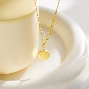 Détail du collier plaqué or 18k avec pendentif gravé Good Luck sur céramique blanche