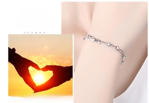 Detail of a 925 sterling silver double-layer bracelet with star charms and silver beads