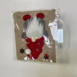 Detailed view of burlap Christmas gnome gift bag featuring red heart and grey hat design