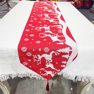 Close-up of festive red knit Christmas table runner with deer and snowflake patterns