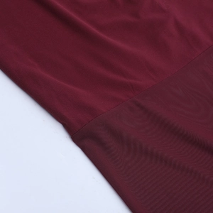 Gros plan détaillé sur le mesh rouge foncé et le tissu uni d'une robe élégante