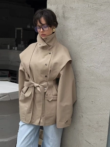 Détail du trench-coat beige avec ceinture, col haut et grandes poches pour femmes chic
