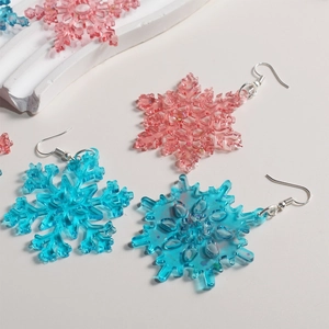 Sparkly resin snowflake earrings in pink and blue colors with silver hooks