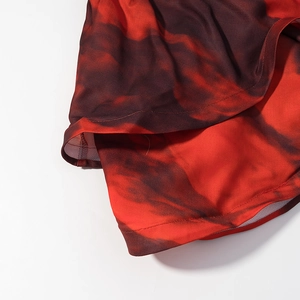 Detail of red-brown tie-dye dress hem with white mesh lining and precise stitching