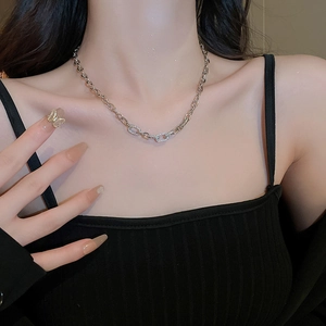 Close-up of a silver geometric necklace featuring a shimmering zircon paved oval link