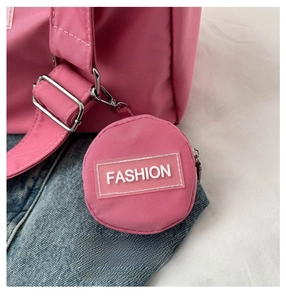 Gros plan d'une mini breloque de sac en nylon rose avec fermeture éclair et étiquette