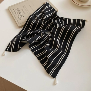 Détail de l'élégant foulard à cheveux rayé noir et blanc avec perles décoratives