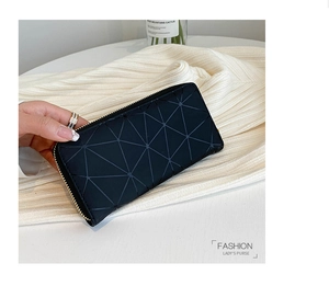 Black geometric laser-cut ladies purse on knit sweater backdrop with gold zipper
