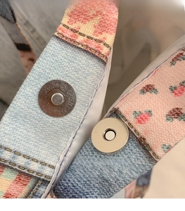 Macro detail of silver magnetic snap button on floral checkered canvas tote bag