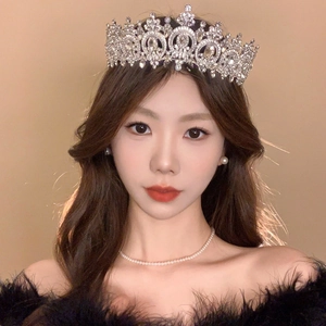 Detailed view of luxury silver rhinestone crown headband worn by a fashion model