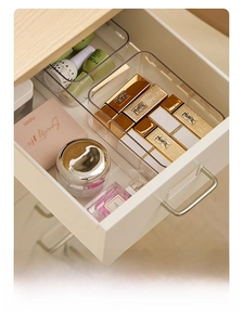 Detailed close-up of transparent acrylic organizers for cosmetics in a white drawer