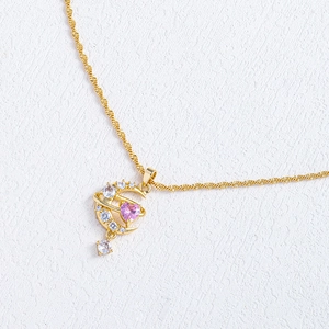 Detailed macro view of moon pendant with pink heart gemstone and sparkling zircons