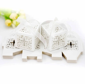 Detail of laser-cut cross gift box showing flat-packed sheets and assembled white ribbon boxes