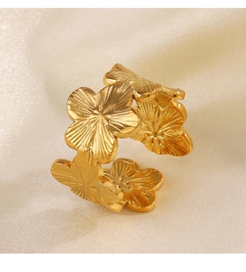 Macro detail of golden flower ring showing textured petals on a beige silk background