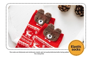 Detail of red Christmas crew socks featuring elastic cuffs and 3D plush bear ears decoration