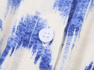 Macro shot of blue and white printed fabric with a white four-hole button detail