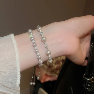 Gros plan d'un bracelet en perles avec entretoises en strass étincelants sur un poignet
