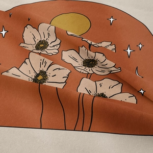 Detail of bohemian tapestry fabric showing warm orange tones and floral moon patterns