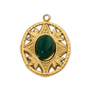 Detailed view of vintage gold pendant with emerald green stone and hollow pattern