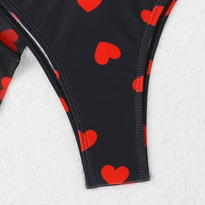Détail du bikini noir avec motif cœurs rouges montrant les finitions de couture soignées