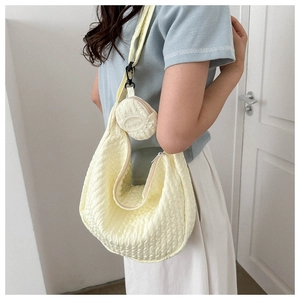 Macro view of pale yellow seersucker crossbody bag with attached round fashion coin purse