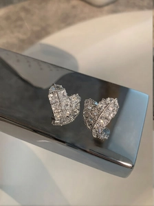 Macro shot of silver-plated heart stud earrings with cubic zirconia pave setting