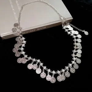 Silver geometric coin fringe waist chain with vintage embossed pendants on black velvet
