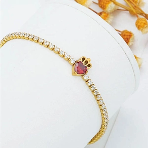 Gold plated tennis bracelet with sparkling zircons and a crowned red heart charm