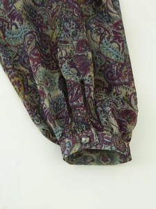 Close-up of chiffon dress cuff featuring purple paisley print with metallic gold threads