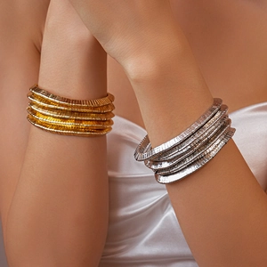 Detailed view of layered gold and silver snake bone textured metallic bangles