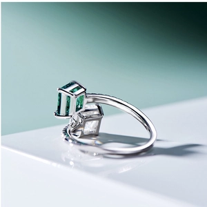 Macro shot of silver ring with square green and clear stones in double stone setting