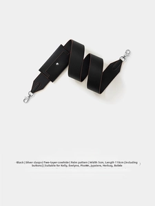 Close-up of black Epsom leather bag strap with silver metal buckle and palm grain texture