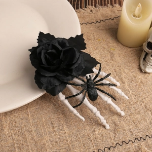 Halloween hair clip with black rose, skeletal hand and spider on rustic linen background