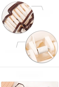 Detail of a bicolored resin hair claw clip showing polished edges and a strong metal spring