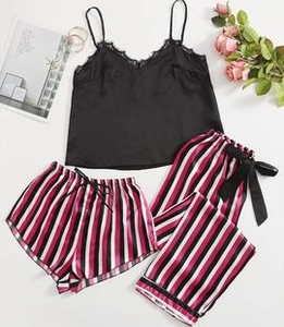 Detailed view of women's silk camisole with lace neckline and striped pajama set