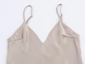 Dettaglio del top in raso champagne con profondo scollo a V e spalline sottili ed eleganti