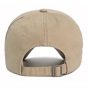 Detail of adjustable metal buckle and strap on back of khaki cotton baseball cap