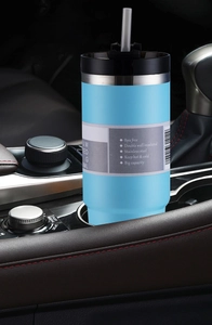 Blue stainless steel vacuum insulated tumbler with straw in a car cup holder