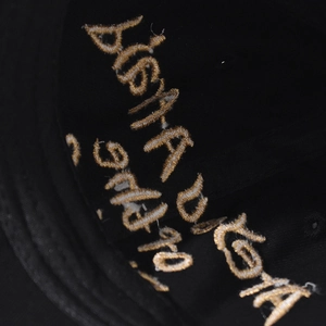 Macro shot of gold embroidery detail with DISTA text on a black vintage baseball cap