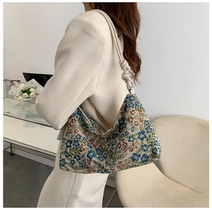 Close-up of vintage floral jacquard fabric and twisted rope knot strap of the shoulder bag