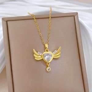 Luxurious gold winged heart necklace with sparkling zircon pendant on white silk fabric