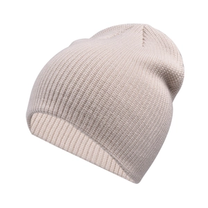 Close-up of thick ribbed knit texture on a warm beige winter beanie hat for outdoor