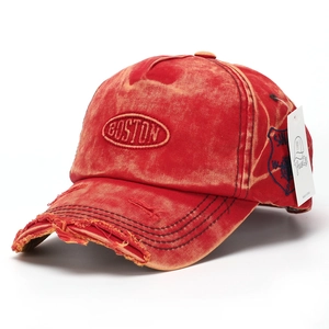 Close-up of red distressed denim baseball cap featuring Boston embroidery and ripped details